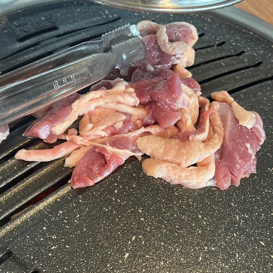Raw duck grilling over charcoal