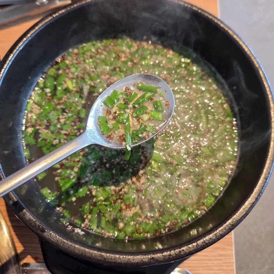 A bowl of duck soup ladled out