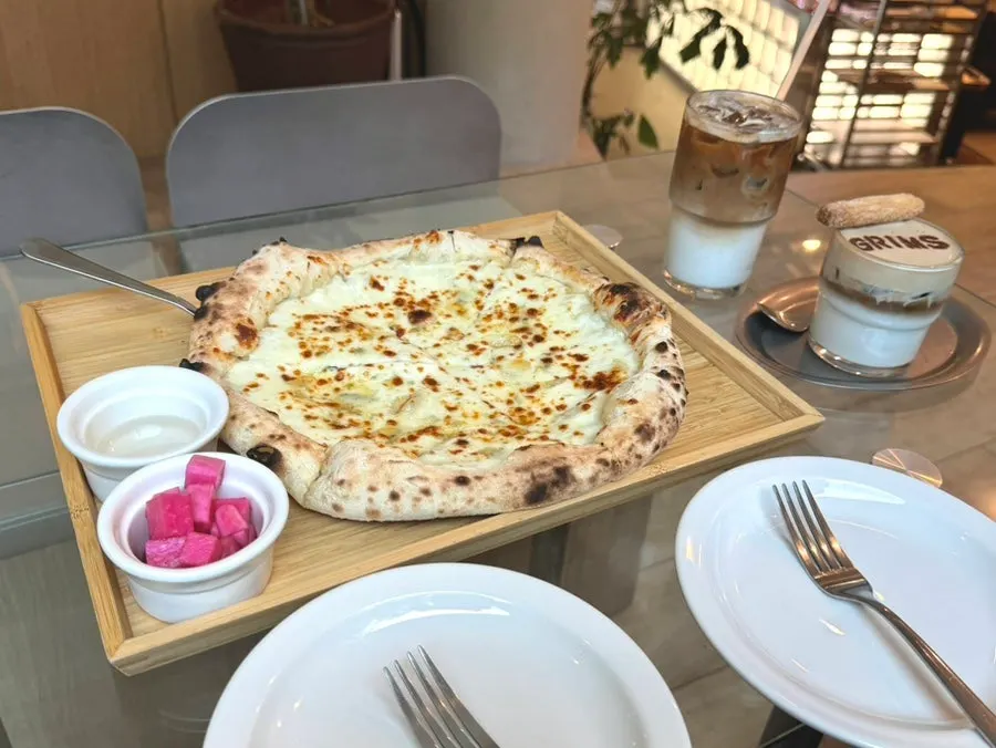 Table setting with Geurimseu butter latte, vanilla latte, and gorgonzola pizza