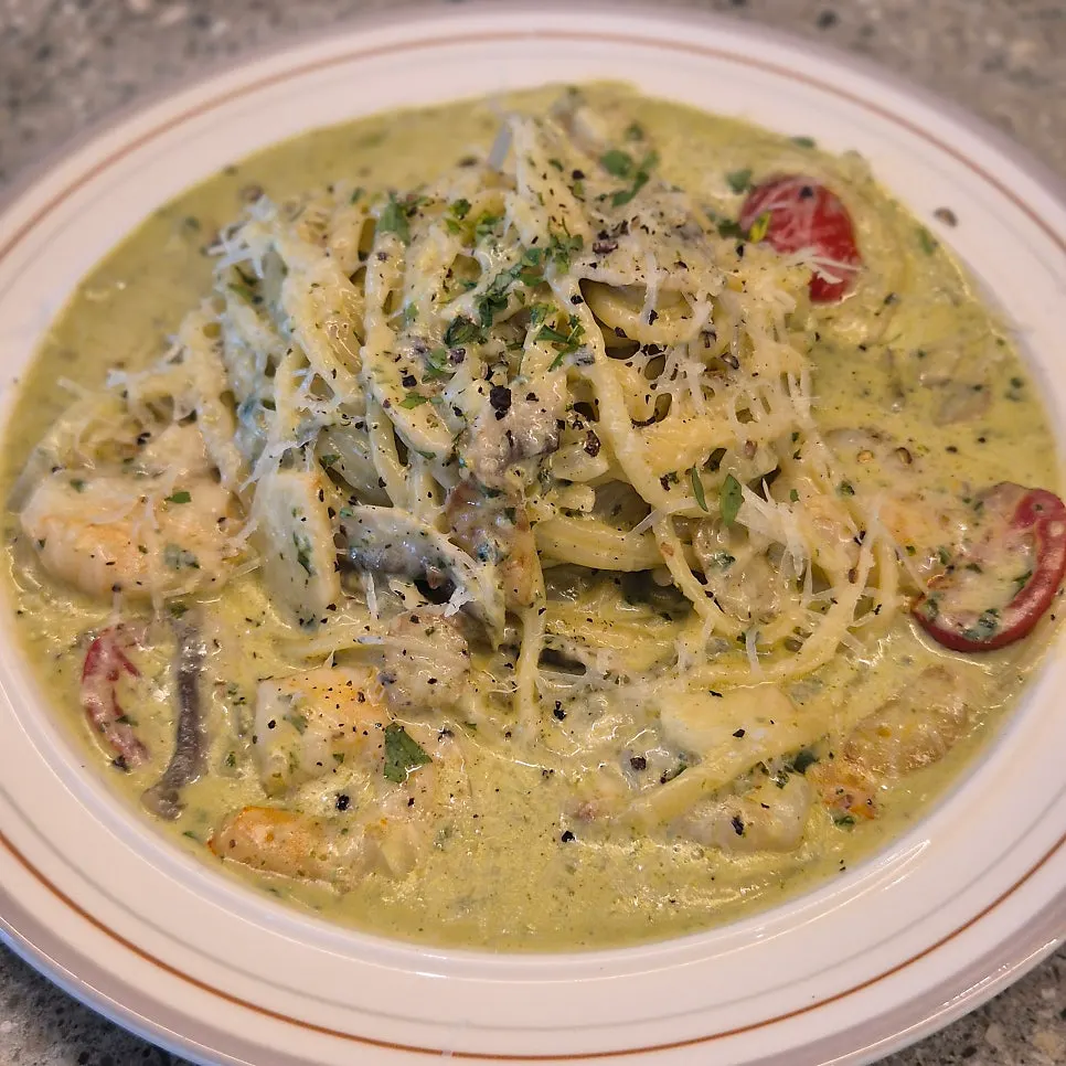 A plate of basil cream pasta with shrimp