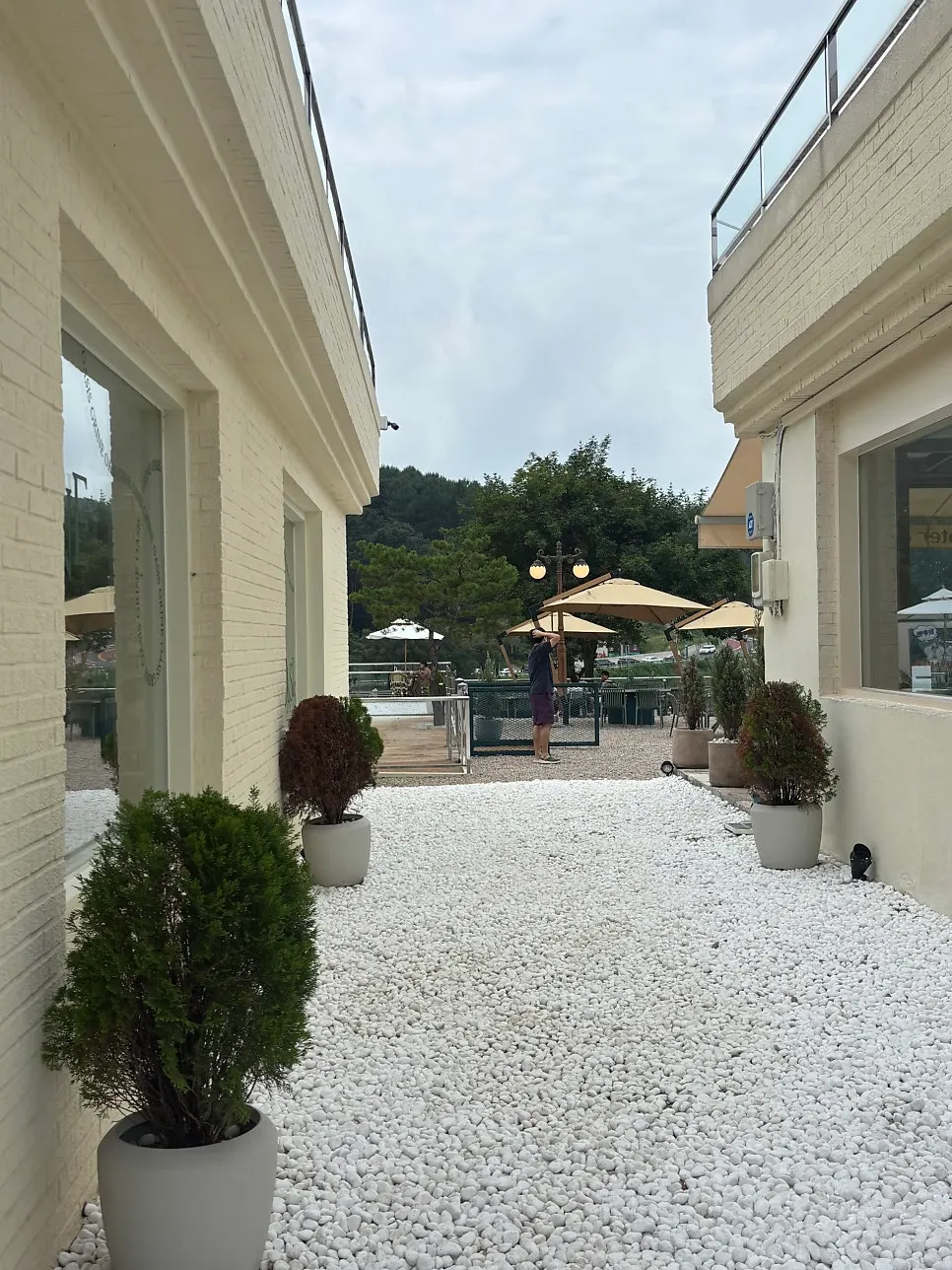 Pemandangan gedung utama dan annex dengan area kafe outdoor di tengah