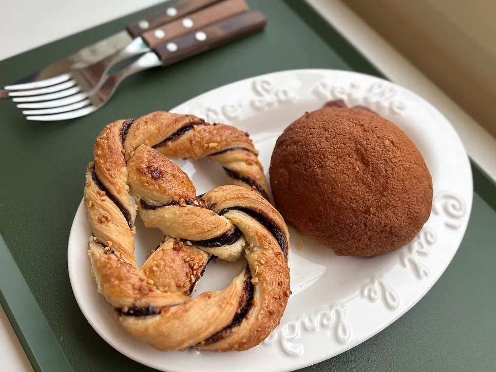 Meja dengan roti coklat, bun, dan minuman