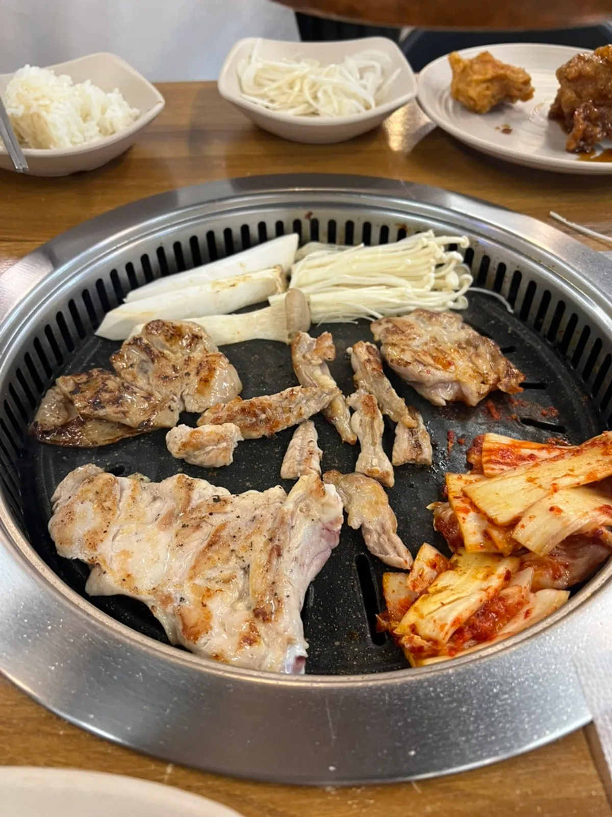 Kimchi and enoki mushrooms grilling next to the dakgalbi