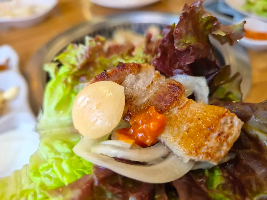 Pork belly grilling alongside dakgalbi