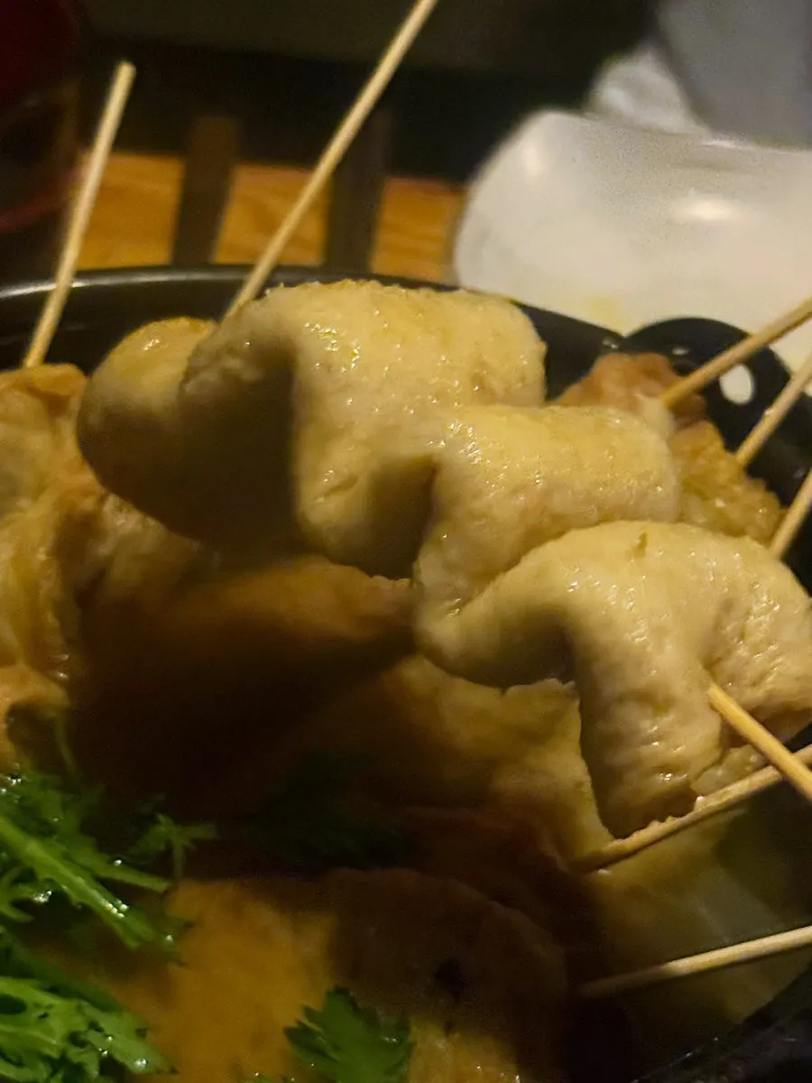 A bite of long fish cake skewer