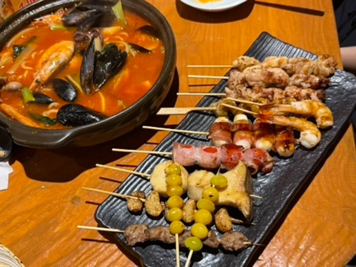 Skewers grilling over open flame at the open kitchen