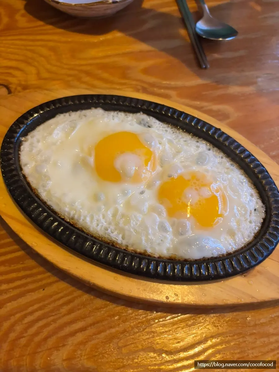 Telur goreng atas plat besi sebagai lauk percuma