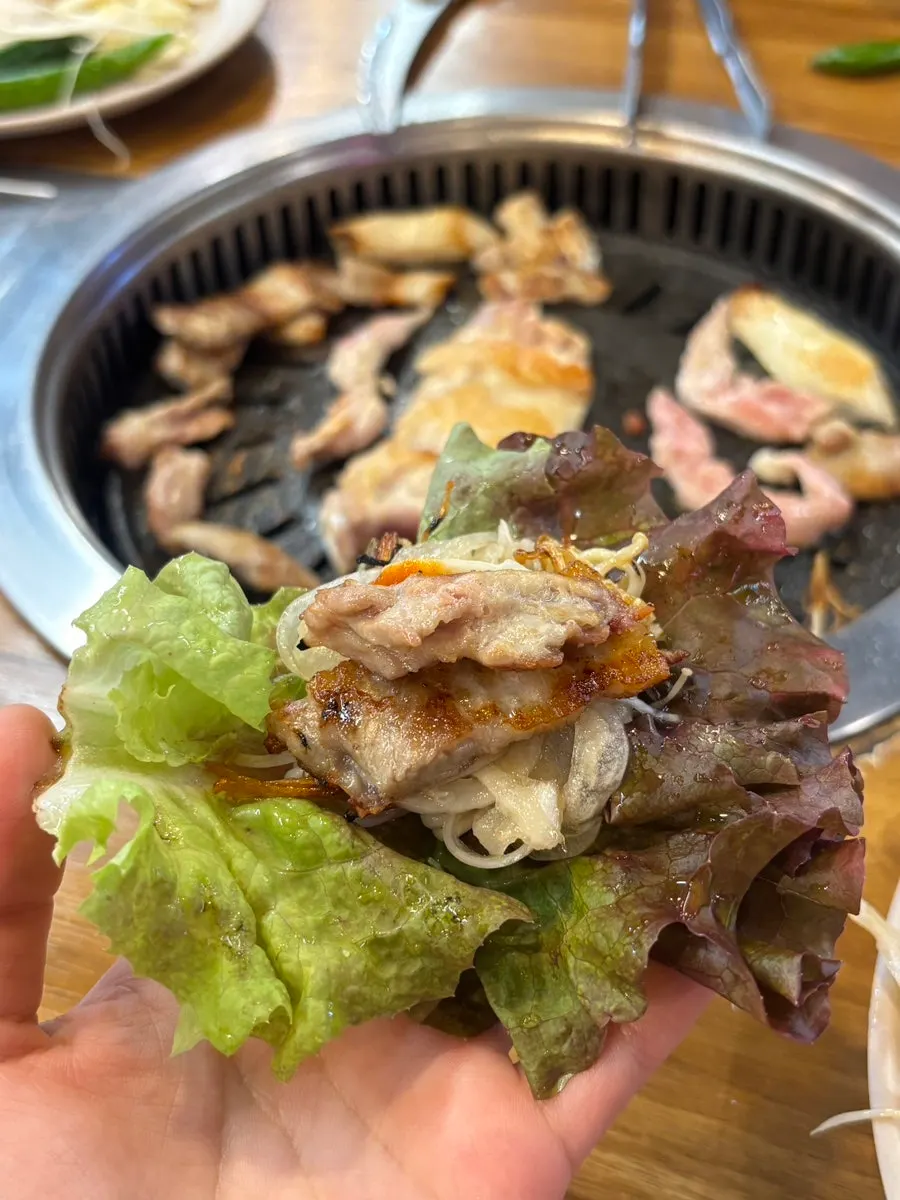 Lettuce wrap topped with radish pickle and pickled onion