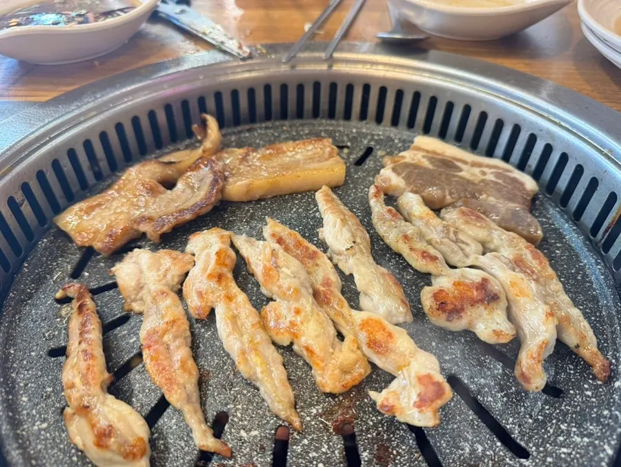 A wrap of dakgalbi with pickled radish and vegetables