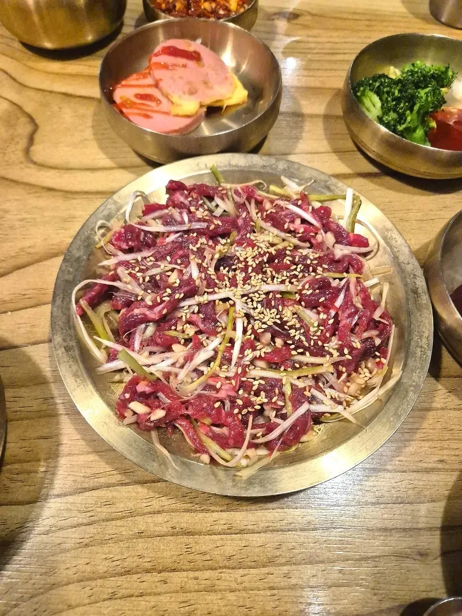 A single piece of yukhoe picked up with chopsticks