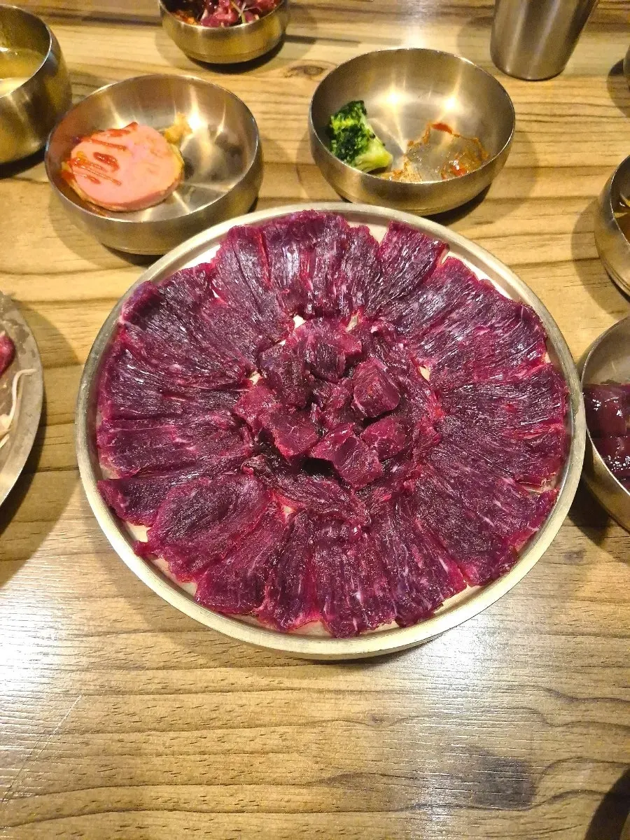 A chewy piece of raw beef being picked up