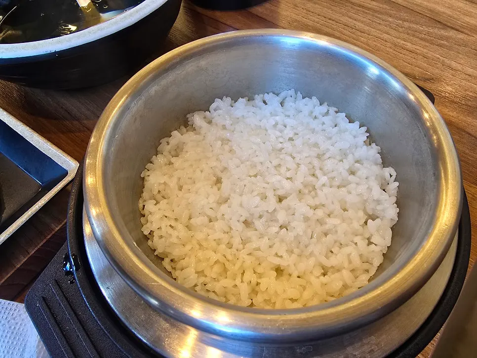 Hot pot with rice scooped out and water poured in