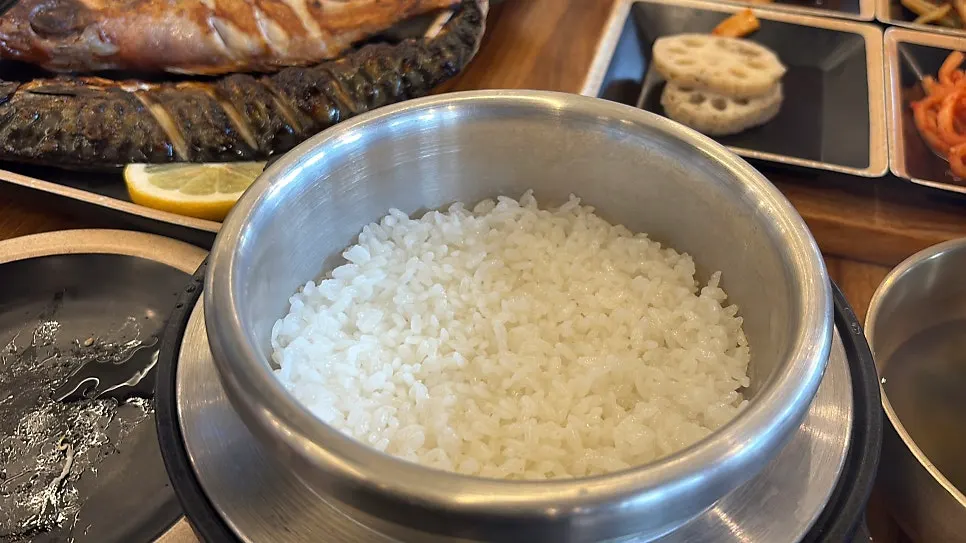 Full table spread of grilled fish and hot pot rice