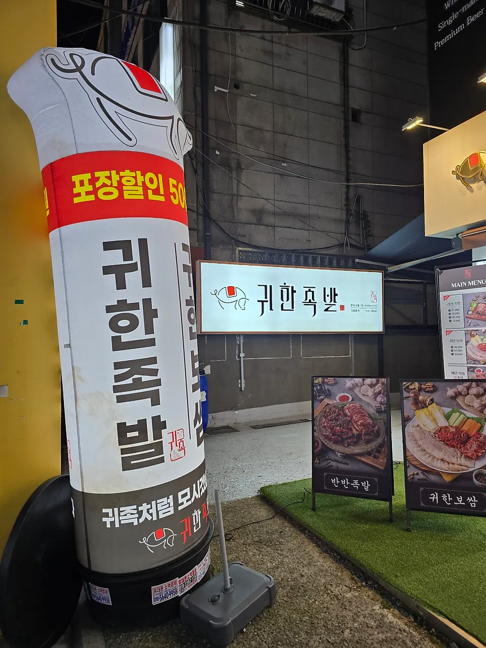 Storefront of Gwihanjokbal Yeonsinnae with an inflatable sign and wood-tone signage
