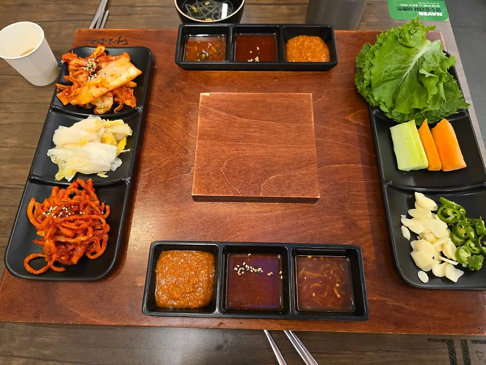 Wooden tray of the Gwihanjokbal set surrounded by sauces and side dishes