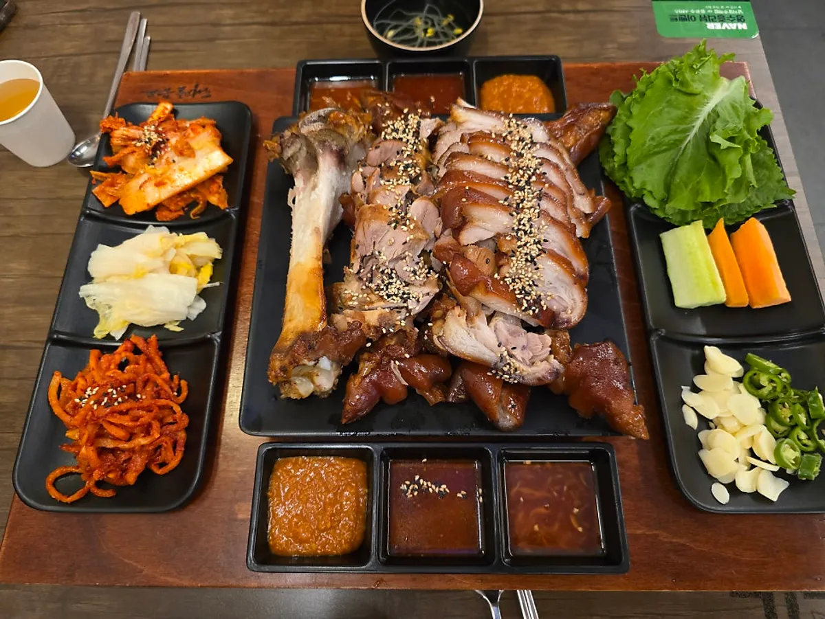 Table setting with radish salad, white kimchi, bossam kimchi, and wrap vegetables