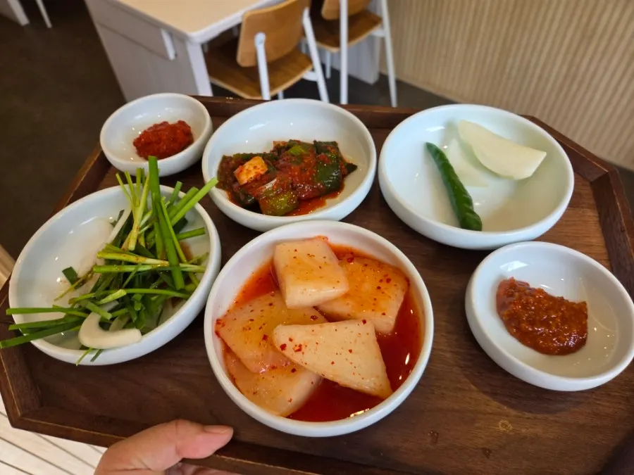 Self-serve side dishes plated from the bar at Gujeon Gukbap