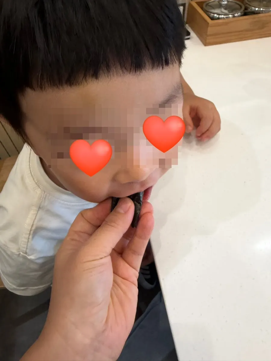 Toddler eating sticky rice with seaweed