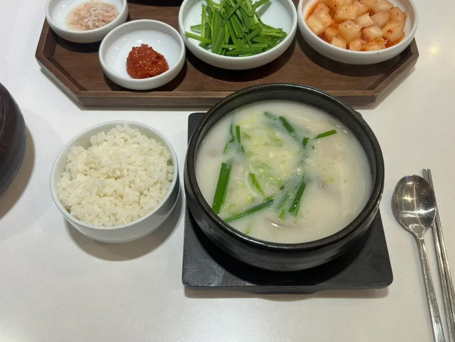 Gukbap served in an earthenware bowl with side dishes