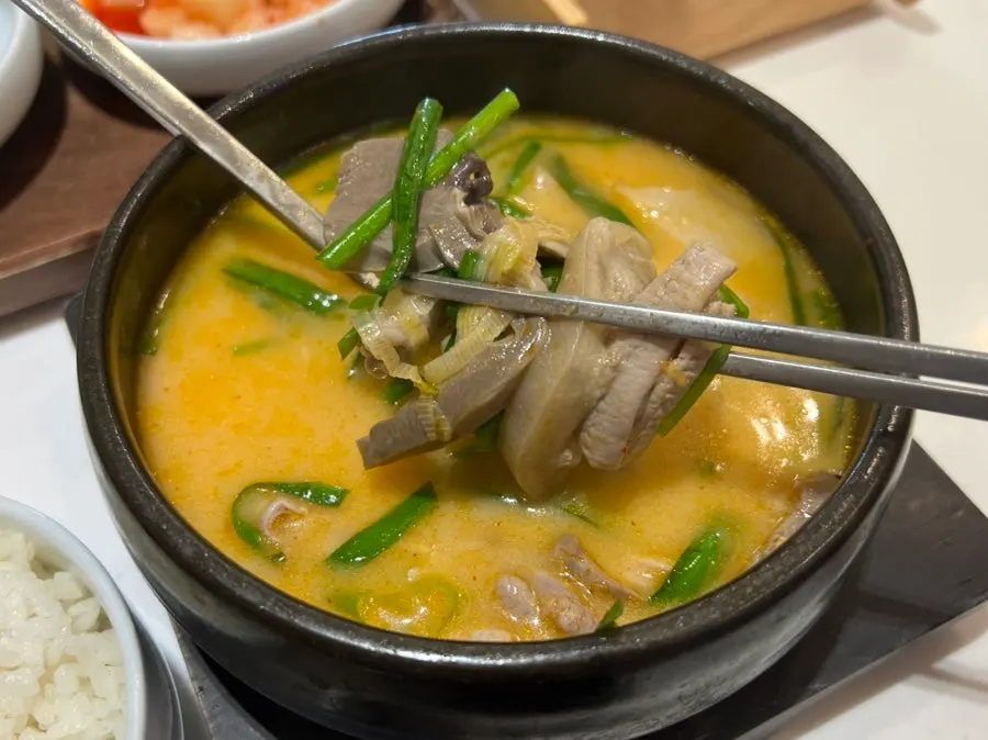 Spicy gukbap topped with chives and kimchi