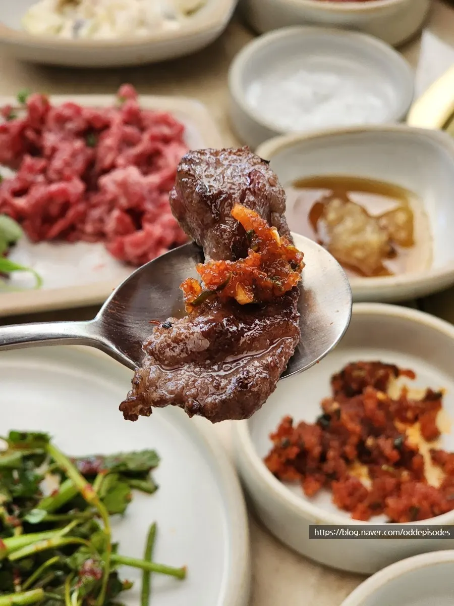 A spread of side dishes: scallions, pickled onion, japchae