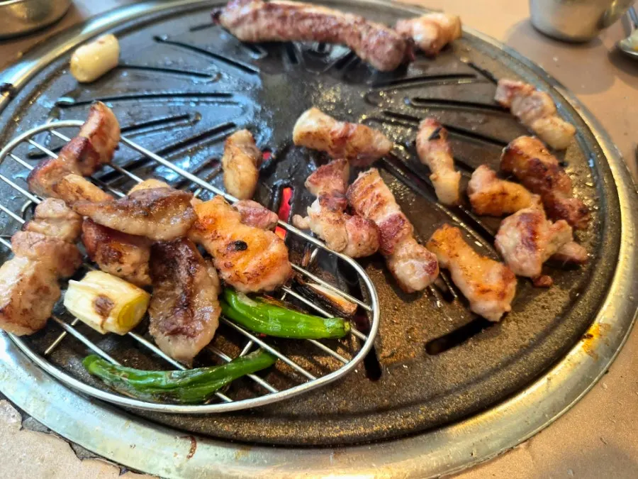 A piece of fresh galbi with salt and green onion kimchi