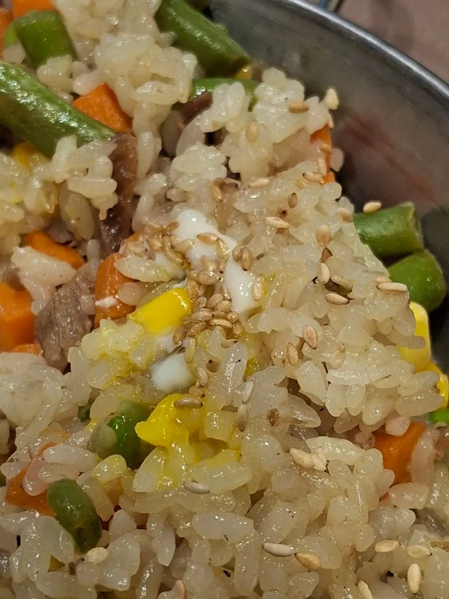 A spoonful of beef fried rice with vegetables