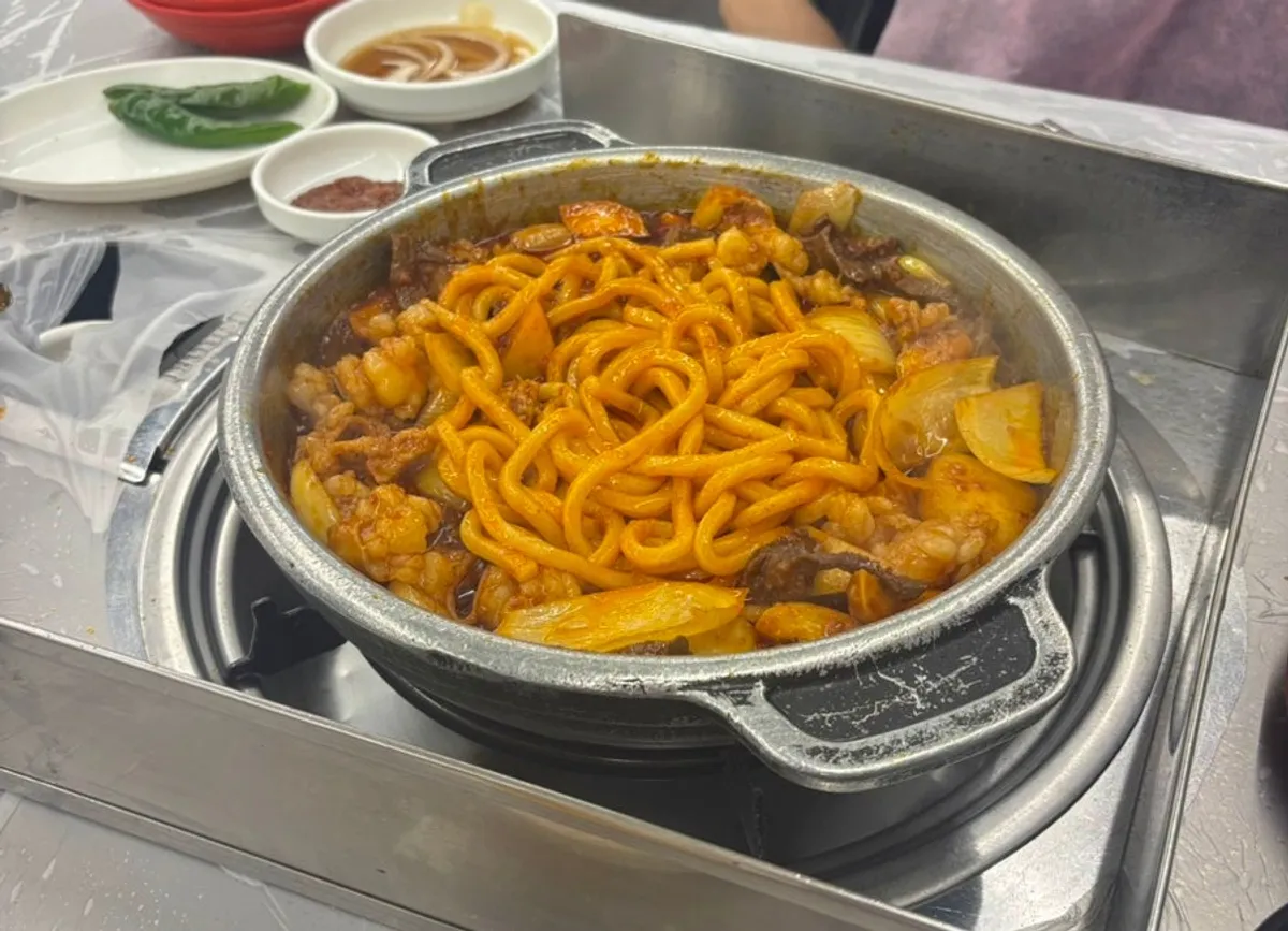 Yangopchang con salsa y udon sari sobre la parrilla de piedra