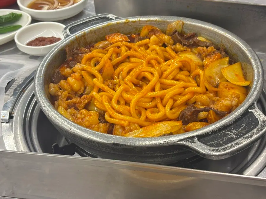 Udon sari mezclándose y asándose en la parrilla con salsa