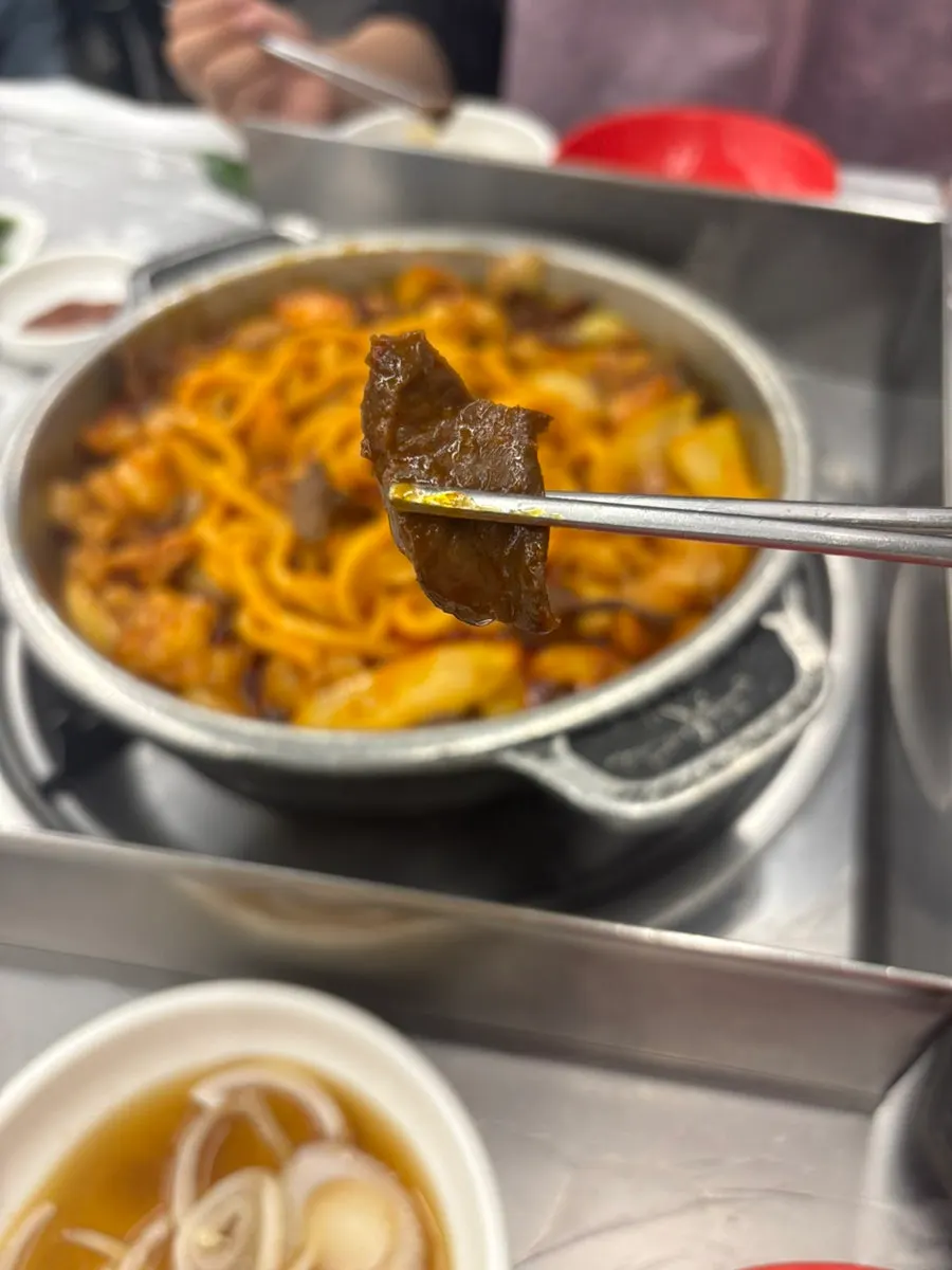 Fideos udon rojos de salsa junto al gopchang