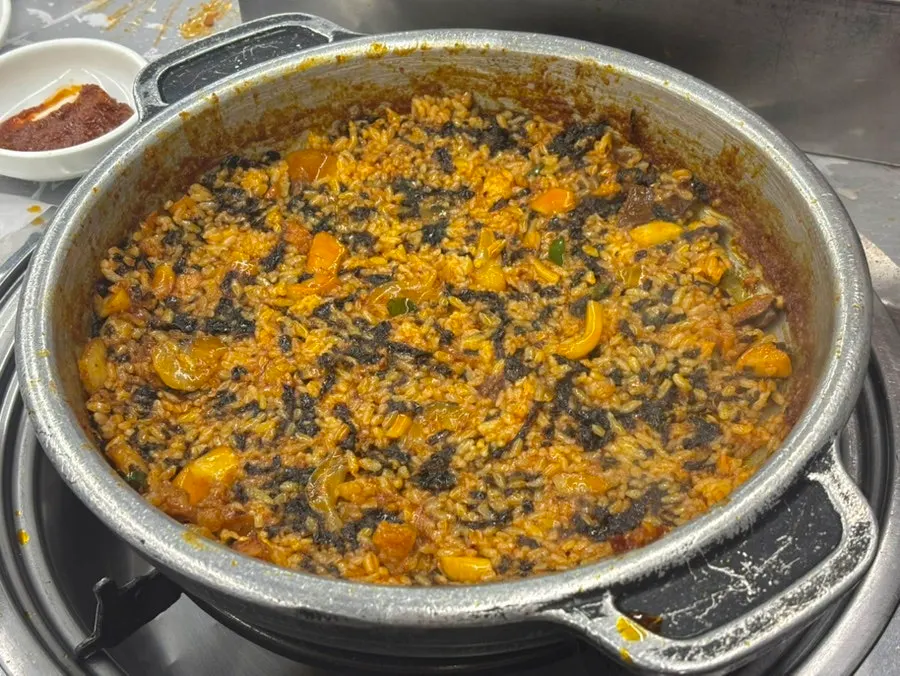 Arroz frito cocinándose en la salsa que queda