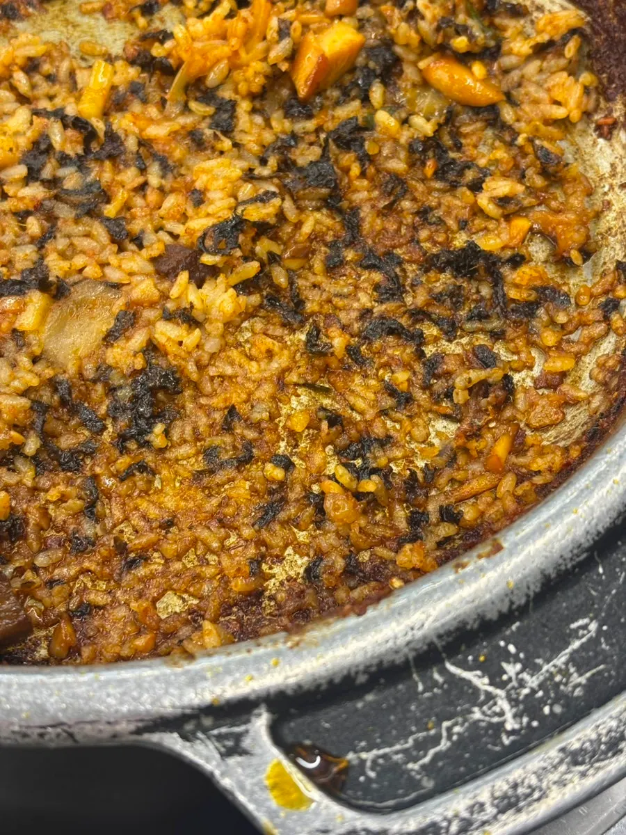 Restos tostados del arroz frito rascados con la cuchara