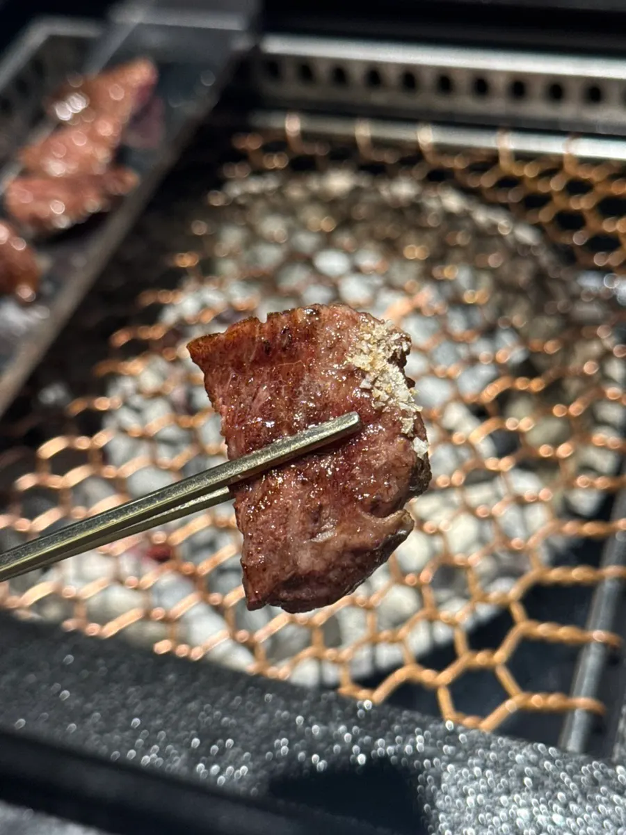 Vertical shot of hanwoo grilling over charcoal