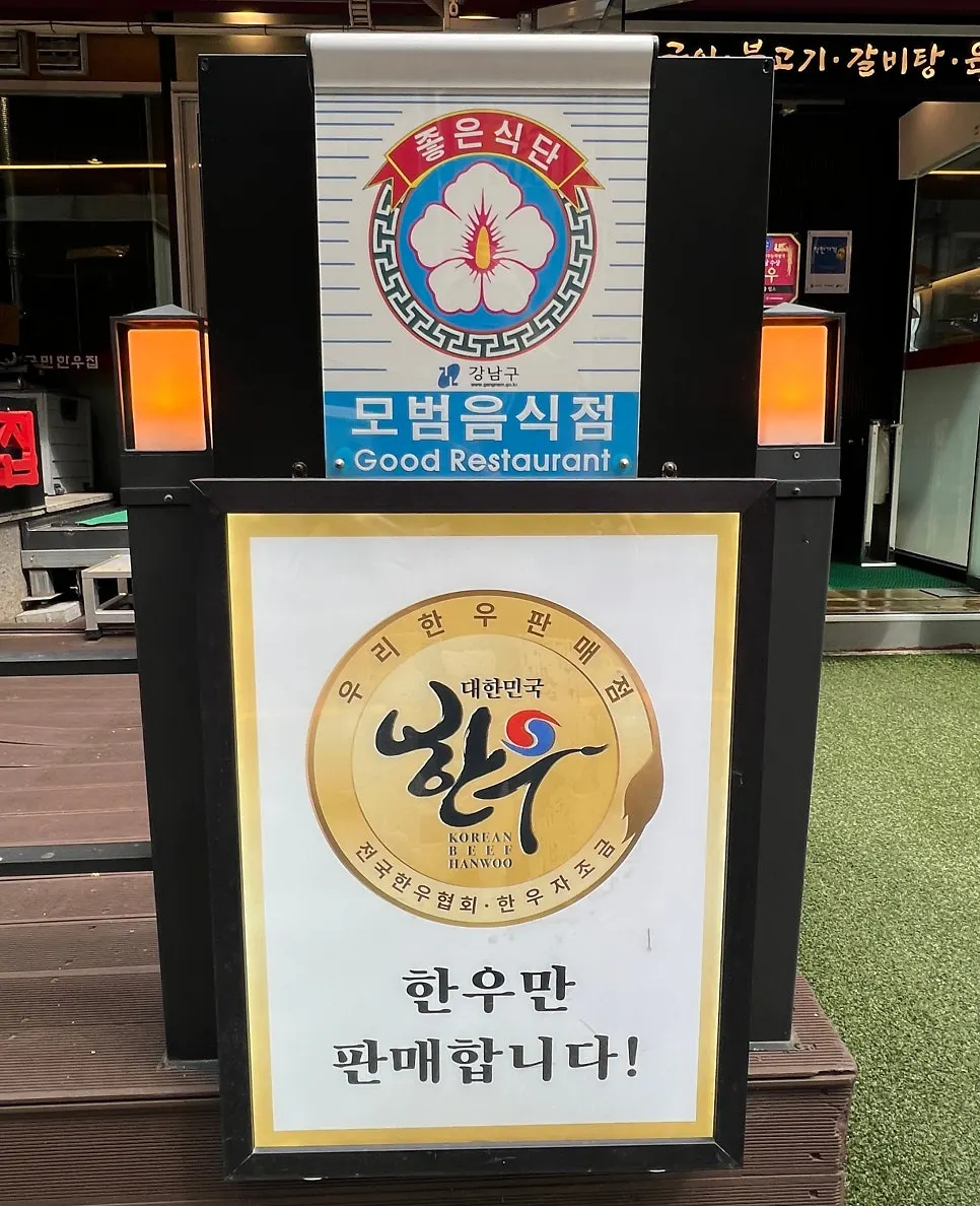 Gangnam-gu Model Restaurant plaque and 'hanwoo only' sign at the entrance