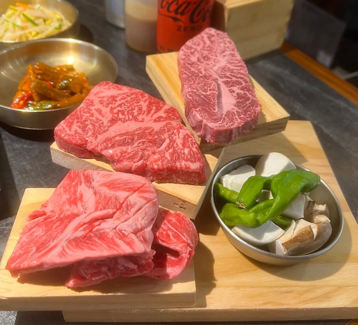 Three cuts of the Gukdae assorted hanwoo set on a wooden board
