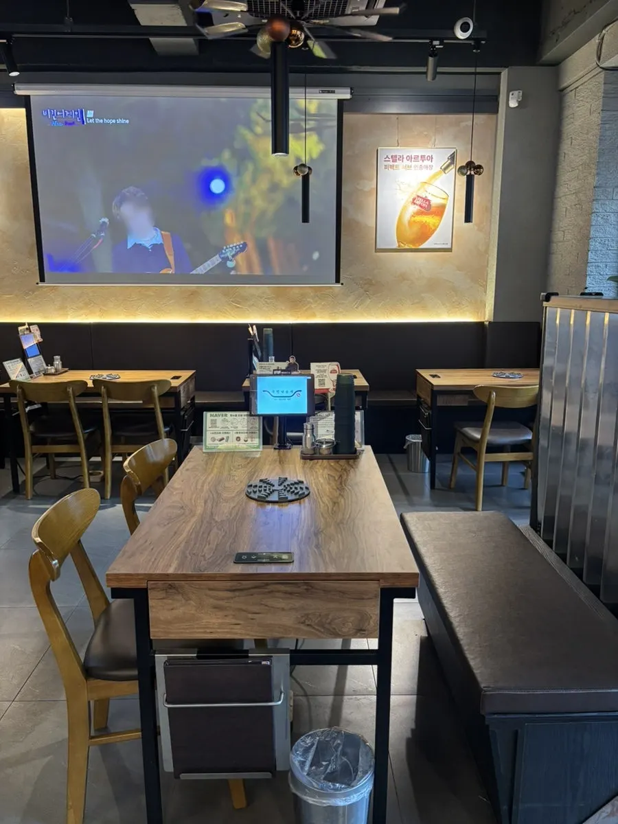 Salón del local con la pantalla gigante visible