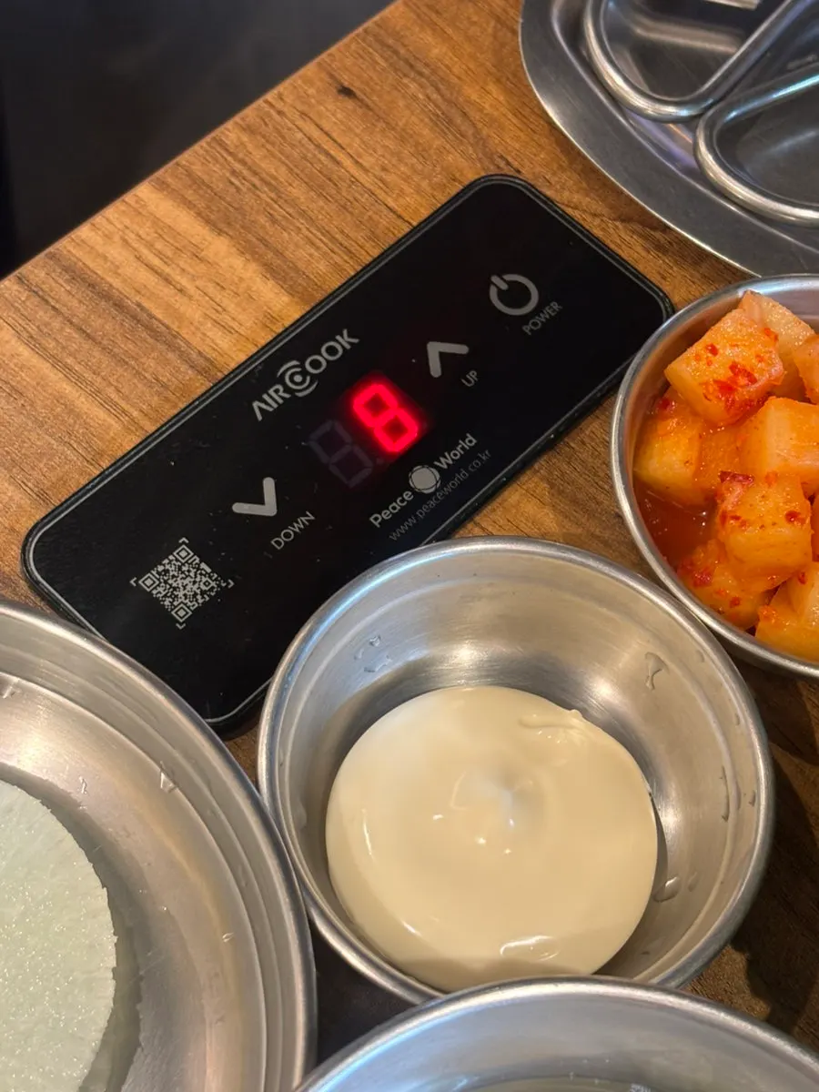 Botones para ajustar la temperatura de la inducción junto a la mesa