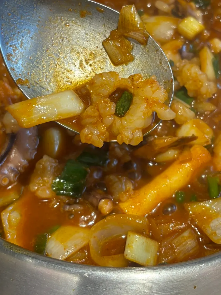 Callos y pastel de arroz en el caldo hirviendo