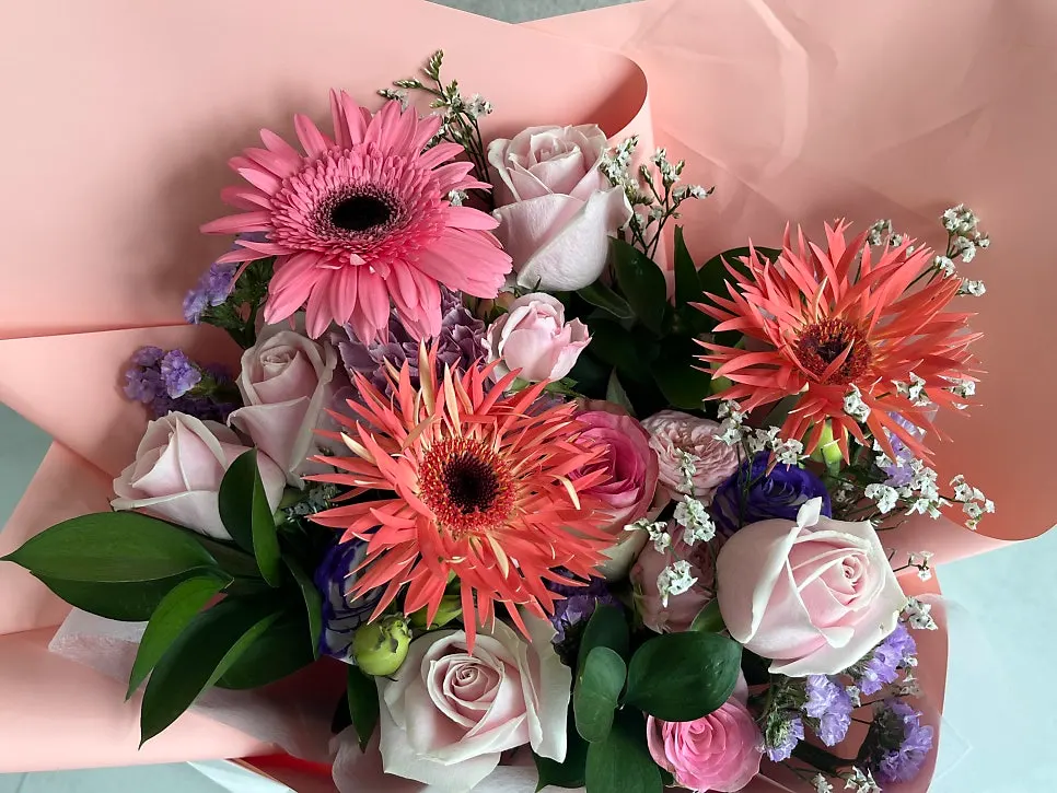 연한 핑크색 포장지로 마무리한 생일 꽃다발