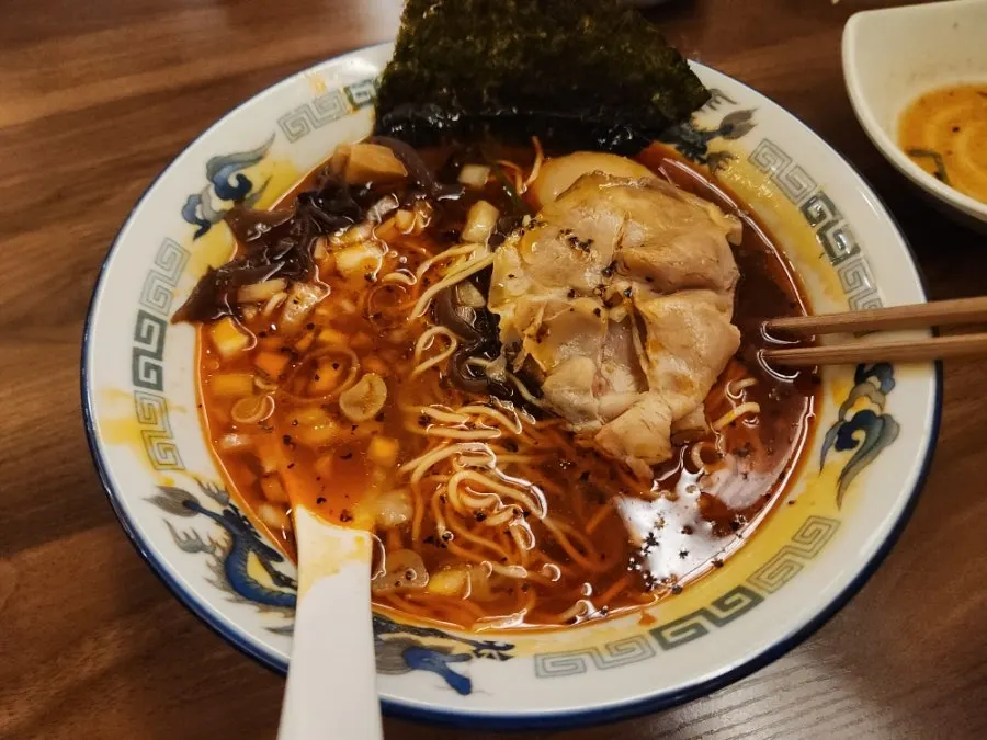 Two thin slices of chashu pork on top of the shoyu ramen