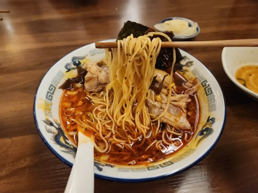 Chewy ramen noodles lifted with chopsticks