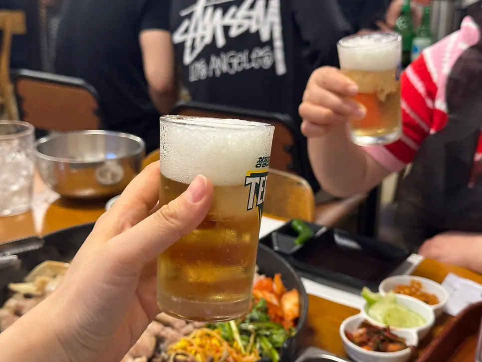 노릇하게 구워지는 삼겹살과 곁들임 채소