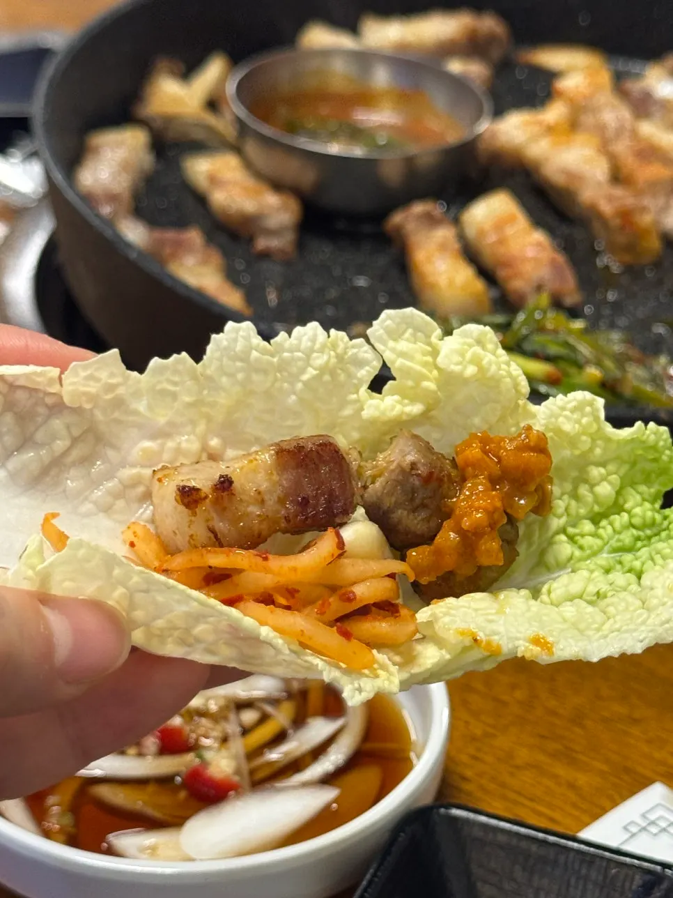 젓가락으로 집어 든 구운 삼겹살