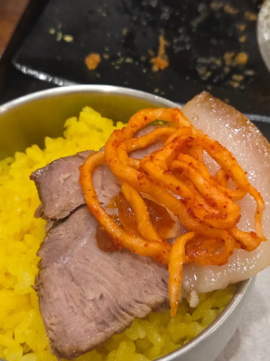 수육에 무생채와 마늘을 올린 한 점