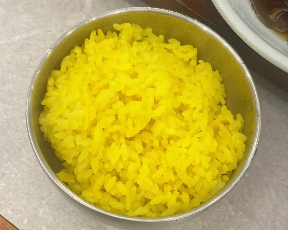 Yellow turmeric rice served with the loach soup