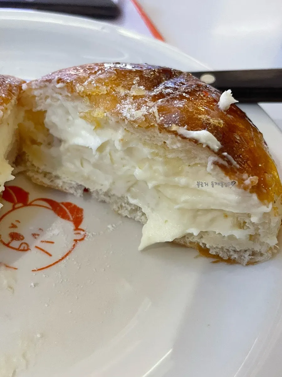 Cross-section of a milk cream donut overflowing with cream