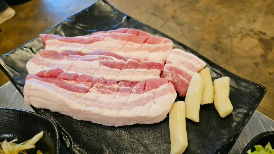 Three servings of fresh pork belly on the grill