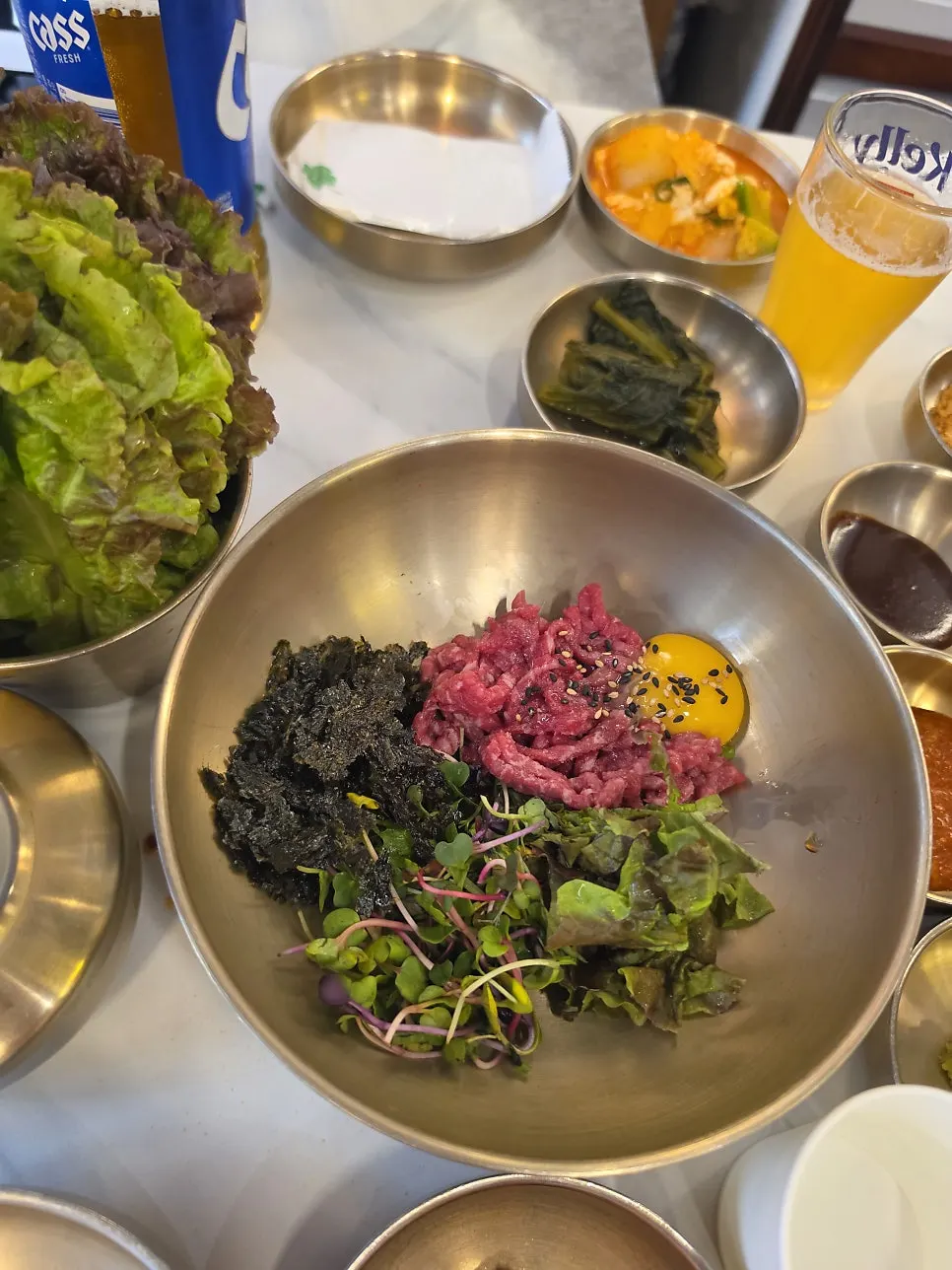 Yukhoe bibimbap topped with raw beef, seaweed flakes and egg yolk