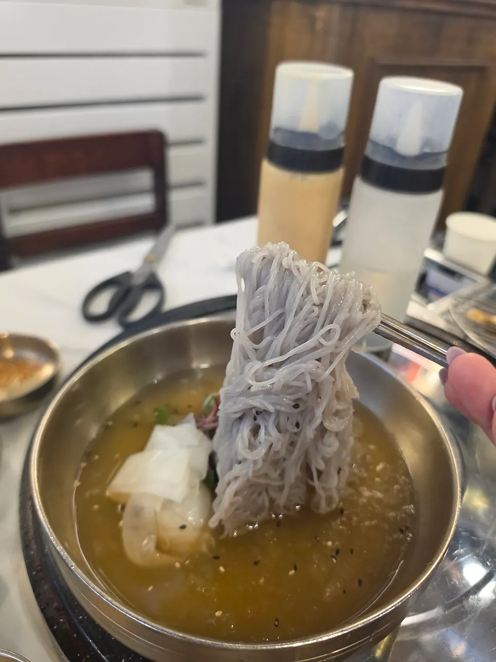 Lifting up a portion of naengmyeon noodles
