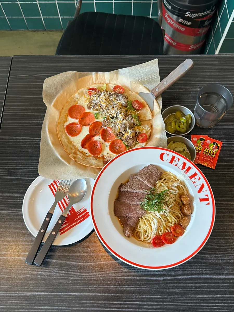 Oil pasta piled with striploin next to the pizza